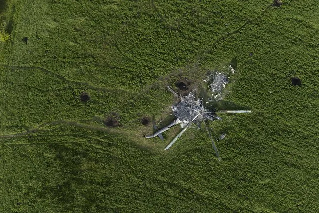 The remains of a destroyed Russian helicopter lie in a field in the village of Malaya Rohan, Kharkiv region, Ukraine, Monday, May 16, 2022. (Photo by Bernat Armangue/AP Photo)