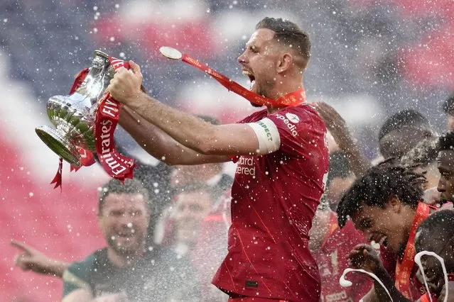 Liverpool's Jordan Henderson celebrates with the trophy at the end of the English FA Cup final soccer match between Chelsea and Liverpool, at Wembley stadium, in London, Saturday, May 14, 2022. (Photo by Kirsty Wigglesworth/AP Photo)