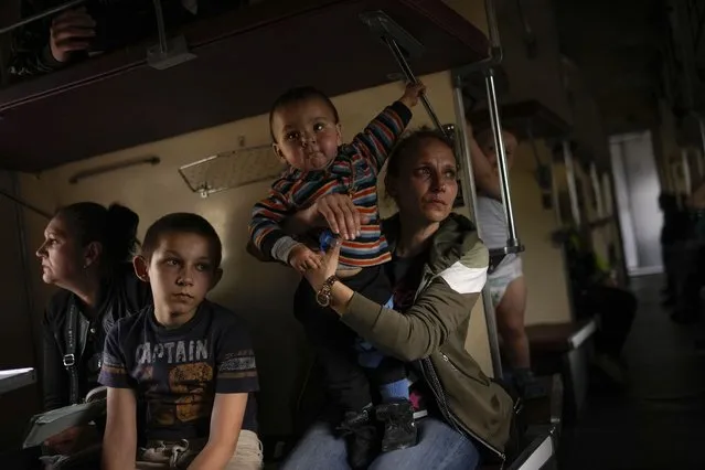 Yana Skakova and her son Yehor who fled from Lysychansk with other people sit in an evacuation train at the train station in Pokrovsk, eastern Ukraine, eastern Ukraine, Saturday, May 28, 2022. (Photo by Francisco Seco/AP Photo)