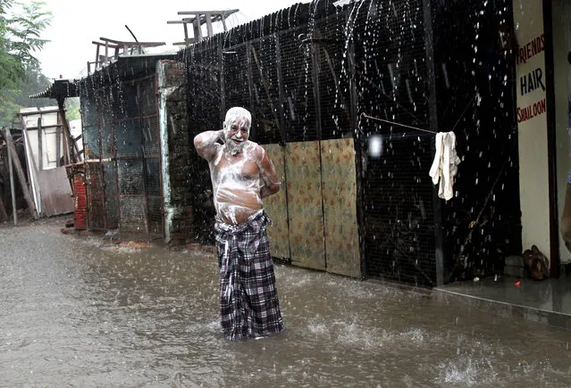 A man soaps himself up and takes bath during monsoon rains in Allahabad, India, Tuesday, July 11, 2017. The monsoon season in India lasts from June to September. (Photo by Rajesh Kumar Singh/AP Photo)