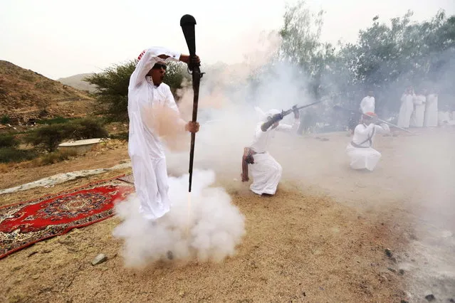 A man fires a weapon as he dances during a traditional excursion near the western Saudi city of Taif, August 8, 2015. Saudis usually party in such excursions as they celebrate weddings or graduations. (Photo by Mohamed Al Hwaity/Reuters)