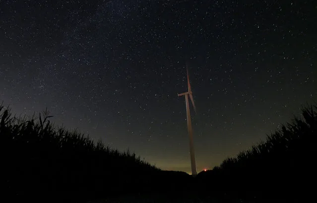 In this photo taken with long exposure, a wind turbine is set against a starry sky Thursday, August 13, 2015, near Marshalltown, Iowa. The annual Perseid meteor shower reaches its peak on Wednesday and Thursday. (Photo by Charlie Riedel/AP Photo)