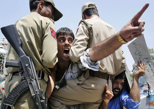 Kashmiri protesters shout slogans against Israel from inside a police vehicle after they were detained during a protest in Srinagar, India, Monday, July 14, 2014. The protest was against the Israeli military operation in Gaza strip. Palestinian militants in the Gaza Strip launched an unmanned drone aircraft at Israel on Monday and Israeli air attacks killed four Gaza residents, as the conflict between the antagonists closed out its first week with no end in sight. (Photo by Mukhtar Khan/AP Photo)