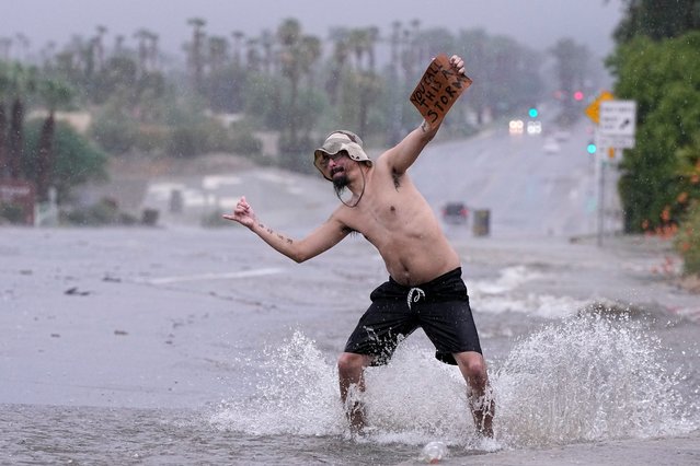 Joseph Wolensky stands in the street with a sign that says “You call this a storm?” Sunday, August 20, 2023, in Palm Desert, Calif. Forecasters said Tropical Storm Hilary was the first tropical storm to hit Southern California in 84 years, bringing the potential for flash floods, mudslides, isolated tornadoes, high winds and power outages. (Photo by Mark J. Terrill/AP Photo)