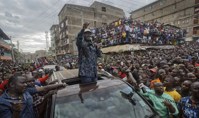 Kenyan opposition leader Raila Odinga gestures to thousands of supporters gathered in the Mathare area of Nairobi, Kenya Sunday, August 13, 2017. Odinga on Sunday condemned police killings of rioters during protests after the country's disputed election and is urging supporters to skip work Monday. (Photo by Ben Curtis/AP Photo)