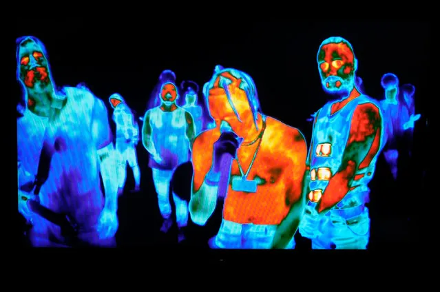 Travis Scott (C) with Tomo Milicevic (L) and Jared Leto of Thirty Second to Mars are seen performing through thermal technology cameras on a television screen during the 2017 MTV Video Music Awards at The Forum on August 27, 2017 in Inglewood, California. (Photo by Larry Busacca/MTV1617/Getty Images for MTV)