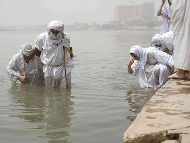 Members of the Sabean Mandaeans, a pre-Christian sect that follows the teachings of John the Baptist, perform their rituals in the Tigris River in Baghdad, Iraq, Saturday, July 16, 2022. The Sabean Mandaeans are marking the new year which they celebrate as a five-day holiday. (Photo by Hadi Mizban/AP Photo)
