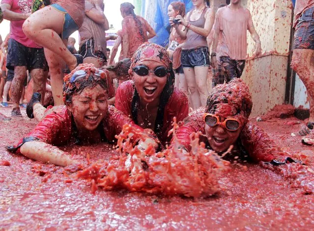 Revelers play in tomato pulp after the annual “Tomatina” (tomato fight) in Bunol, near Valencia, Spain, August 26, 2015. (Photo by Heino Kalis/Reuters)