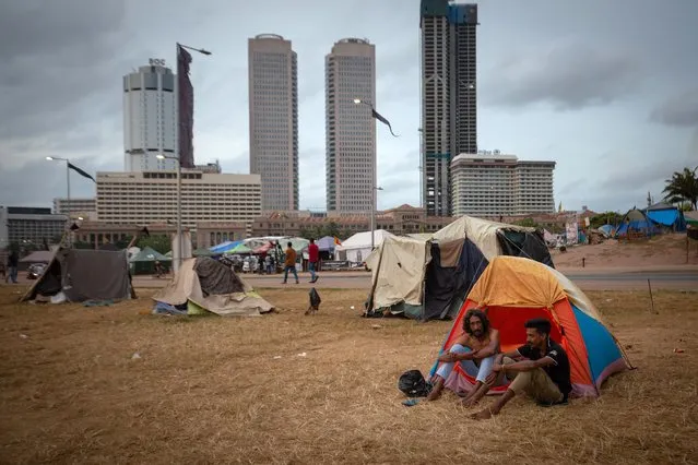 Protestors sit outside their tents and talk at the site of a protest on July 17, 2022 in Colombo, Sri Lanka. After months of sustained street protests over the country’s economic collapse, Sri Lanka’s parliament will elect a new president who will serve the rest of the current term after president Gotabaya Rajapaksa fled the country. (Photo by Abhishek Chinnappa/Getty Images)