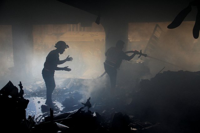 Palestinians work to extinguish fire at a school sheltering displaced people, after it was hit by an Israeli strike, in Gaza City on November 14, 2024. (Photo by Mahmoud Issa/Reuters)