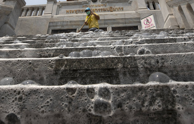 Soap bubbles cover the steps of Wat Taimit Temple as volunteers clean the public areas as a safety precaution against the new coronavirus Wednesday, March 18, 2020, in Bangkok, Thailand. Thailand's government has enacted stronger measures to combat the spread of the coronavirus, including postponing the country's biggest holiday, shutting down schools, movie theaters and closing bars. (Photo by Sakchai Lalit/AP Photo)
