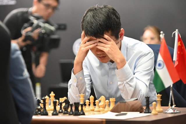 China's chess grandmaster Ding Liren competes against India's grandmaster Gukesh Dommaraju during game 14 of the 2024 FIDE World Championship in Singapore on December 12, 2024. World chess champion Ding Liren, 32, from China, is defending his crown against 18-year-old Indian prodigy Gukesh Dommaraju, who is seeking to make history by becoming the youngest ever undisputed titleholder in the sport. (Photo by Simon Lim/AFP Photo)