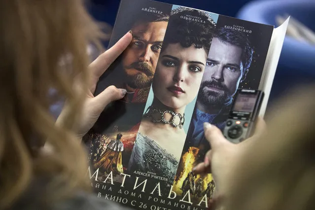 In this Tuesday, June 13, 2017 file photo, a woman holds an official poster of Russian film director Alexei Uchitel's film “Matilda” at a news conference in Moscow, Russia. Russian police has detained four people suspected of an arson attack linked to a controversial movie about the Russian last czar’s love affair, it was announced on Thursday, September 21, 2017. The movie, “Matilda”, which is set to be released in October, has sparked harsh criticism from hard-line nationalists and some Orthodox believers in Russia. (Photo by Pavel Golovkin/AP Photo)