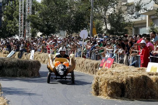 People watch a competitor riding a homemade vehicle without an engine on a 300-metre-track during the Red Bull Soapbox Race in Amman, Jordan September 4, 2015. (Photo by Muhammad Hamed/Reuters)