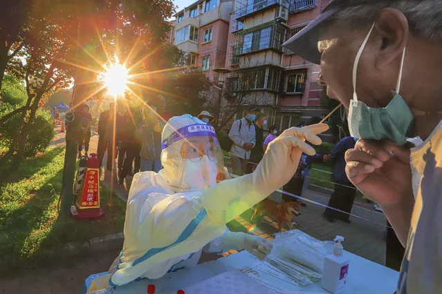 This photo taken on August 31, 2022 shows a health worker taking a swab sample from a man to be tested for the Covid-19 coronavirus in China's northern Tianjin. (Photo by CNS/AFP Photo)