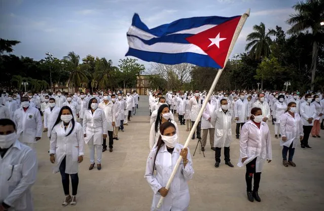 A brigade of health professionals, who volunteered to travel to South Africa to assist local authorities with an upsurge of coronavirus cases, attend the farewell ceremony in Havana, Cuba, Saturday, April 25, 2020. (Photo by Ramon Espinosa/AP Photo)