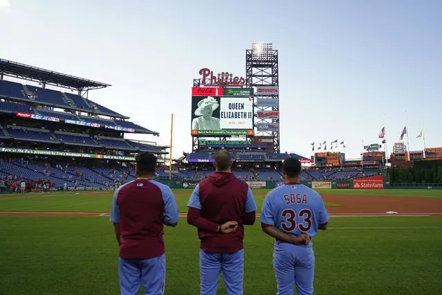 Philadelphia Phillies' players stand before a baseball game against the Miami Marlins for a tribute to Queen Elizabeth II, Britain's longest-reigning monarch who died after 70 years on the throne, Thursday, September 8, 2022, in Philadelphia. (Photo by Matt Slocum/AP Photo)