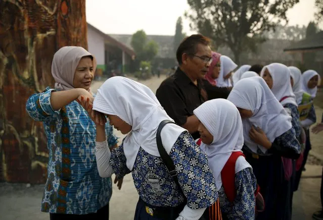 Students pay their respects to their teachers as they are dismissed early from school due to the unhealthy quality of air in Palembang, on Indonesia's Sumatra island, September 10, 2015. (Photo by Reuters/Beawiharta)
