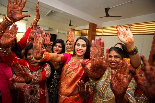 Married women show their hands decorated with henna while they dance during celebrations to mark the Hindu festival of Karva Chauth, in Chandigarh, India October 8, 2017. (Photo by Ajay Verma/Reuters)