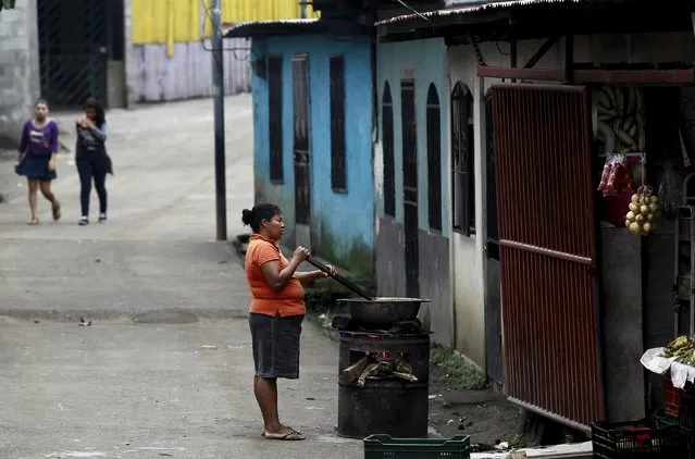 A woman cooks on a wood-fired stove outside her home in a poor neighborhood of La Carpio of San Jose, Costa Rica September 10, 2015. (Photo by Juan Carlos Ulate/Reuters)