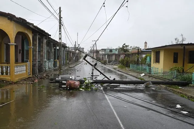A utility pole lies on the street in Consolacion del Sur, Cuba, on September 27, 2022, during the passage of hurricane Ian. Hurricane Ian made landfall in western Cuba early Tuesday, with the storm prompting mass evacuations and fears it will bring widespread destruction as it heads for the US state of Florida. (Photo by Adalberto Roque/AFP Photo)