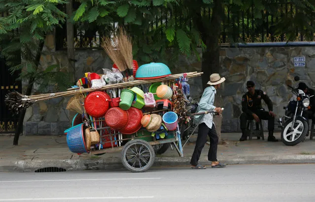 A man pulls a cart loaded with goods for sale along a street in Phnom Penh, Cambodia, August 8, 2016. (Photo by Samrang Pring/Reuters)