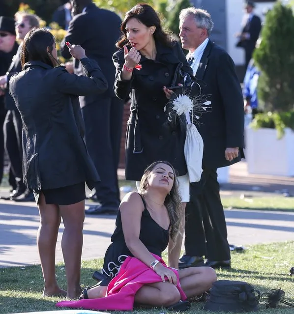 A reveller in heels slumps to the floor next to her mates on 2017 Derby Day at Flemington Racecourse on November 4, 2017 in Melbourne, Australia. (Photo by Splash News and Pictures)