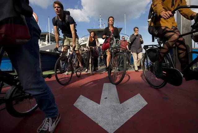 In this September 8, 2014, photo, commuters get off a free ferry connecting parts of Amsterdam. (Photo by Peter Dejong/AP Photo)