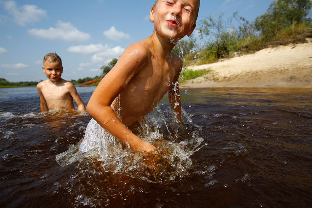 Boys play in the Stviga River on a hot summer day near the village of Pogost, Belarus, August 16, 2017. (Photo by Vasily Fedosenko/Reuters)