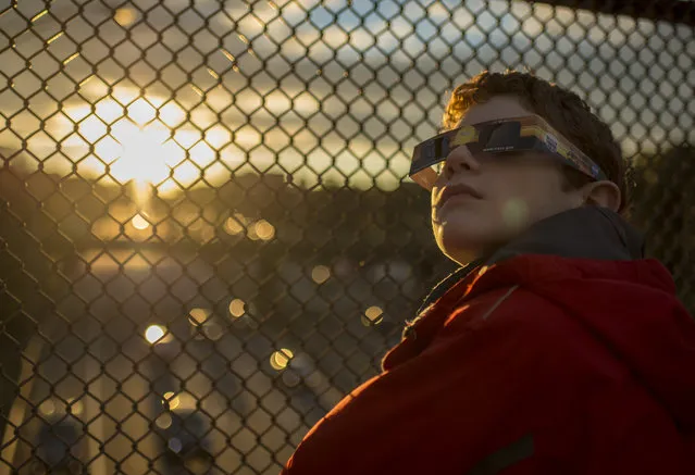 In this handout photo provided by NASA, Alex Frye, 12, uses special viewing glasses to look at a partial solar eclipse from a highway overpass October 23, 2014, in Arlington, Virginia. A partial eclipse occurs when the moon covers a portion of the sun as seen from the Earth. (Photo by Bill Ingalls/NASA via Getty Images)