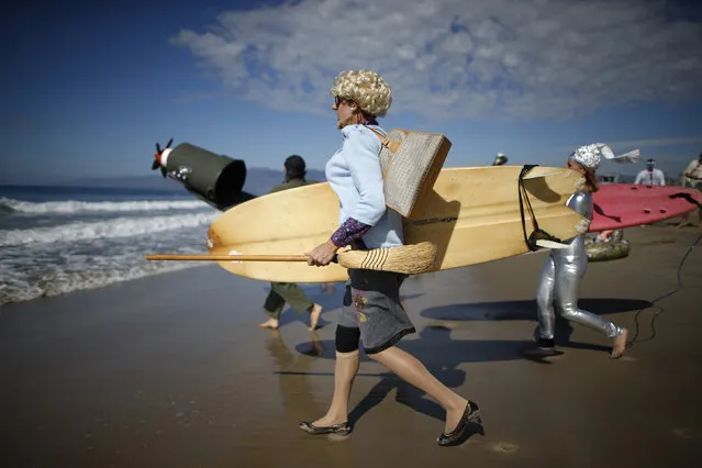 David Nickerson, 24, runs down the beach as Mrs Doubtfire to compete in the 7th annual ZJ Boarding House Haunted Heats Halloween surf contest. (Photo by Lucy Nicholson/Reuters)