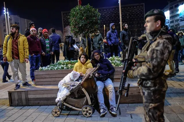 Security members patrol around the city's main Taksim Square as people remember the victims of a deadly New Year's attack a year ago on December 31, 2017. Some of the 37,000 police will be deployed in Istanbul alone on New Year's night, and aome 4,000 members of the gendarmerie and coastguard are also being put on duty, one year after a deadly attack on a nightclub that claimed 39 lives. The authorities have banned any New Year celebrations in Taksim Square in the heart of the European side of the city while a similar measure has been imposed for the lively district of Besiktas  and upscale shopping district of Sisli. (Photo by Yasin Akgul/AFP Photo)