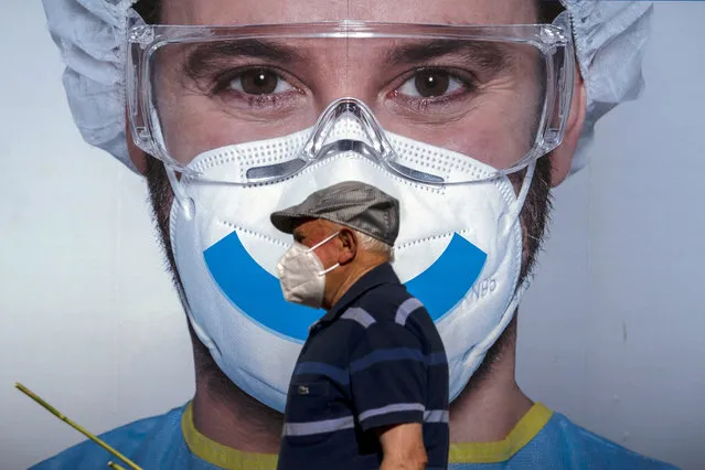 A man wearing face mask walks past an advertising of a private clinic in Barcelona, Spain on Monday August 31, 2020. Spain, with nearly 440,000 infections of the new virus since February, has become western Europe's hardest hit country by a new surging wave of fresh outbreaks. (Photo by Emilio Morenatti/AP Photo)