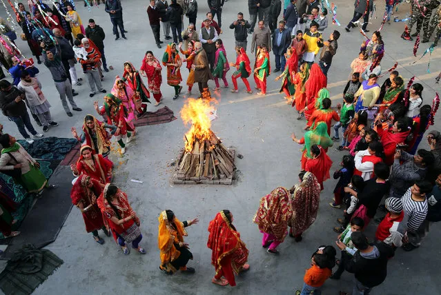 Girls perform a traditional folk dance near a bonfire as they celebrate the Lohri festival, which marks the culmination of winter in many parts of northern India, in Jammu, January 13, 2018. (Photo by Mukesh Gupta/Reuters)