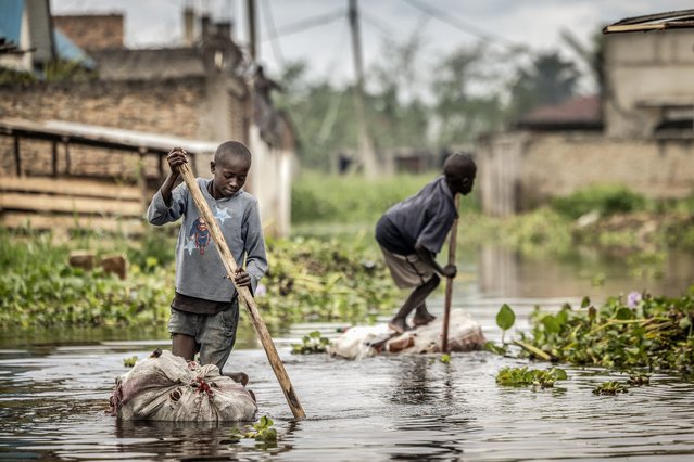 Children float on rafts made from plastic bottles in a flooded residential area, where rising waters from Lake Tanganyika have inundated homes in the Kinyinya III neighborhood of Gatumba, on May 9, 2025. Water levels at lakes in East Africa are rising alarmingly fast. The effects of climate change have worsened the floods of Africa's second-largest lake, often preventing the Ruzizi River from flowing into it. Lake Tanganyika has been above its normal level since 2018 and has been displacing people for years. (Photo by Luis Tato/AFP Photo)
