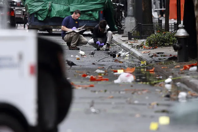 Evidence teams investigate at the scene of Saturday's explosion on West 23rd Street in Manhattan's Chelsea neighborhood, Monday, September 19, 2016, in New York. Ahmad Khan Rahami, wanted in the bombings that rocked Chelsea and a New Jersey shore town was captured Monday after being wounded in a gun battle with police that erupted when he was discovered sleeping in a bar doorway, authorities said. (Photo by Jason DeCrow/AP Photo)