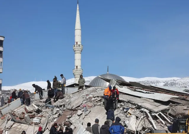 Rescuers and civilians look for survivors under the rubble of collapsed buildings in Kahramanmaras, close to the quake's epicentre, on February 8, 2023. Rescuers in Turkey and Syria braved frigid weather, aftershocks and collapsing buildings, as they dug for survivors buried by an earthquake that killed more than 5,000 people. Some of the heaviest devastation occurred near the quake's epicentre between Kahramanmaras and Gaziantep, a city of two million where entire blocks now lie in ruins under gathering snow. (Photo by Adem Altan/AFP Photo)