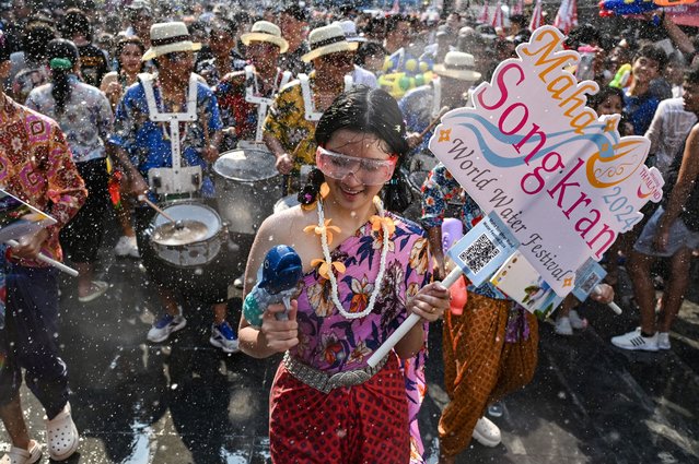 Revellers take part in a parade amidst mass water fights on the eve of Songkran, or Thai New Year, on Khao San Road in Bangkok on April 12, 2024. (Photo by Lillian Suwanrumpha/AFP Photo)
