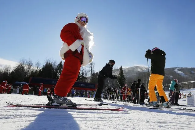 A skier dressed as Santa Claus prepares to participate in a charity run down a slope at Sunday River Ski Resort in Newry, Maine December 7, 2014. (Photo by Brian Snyder/Reuters)