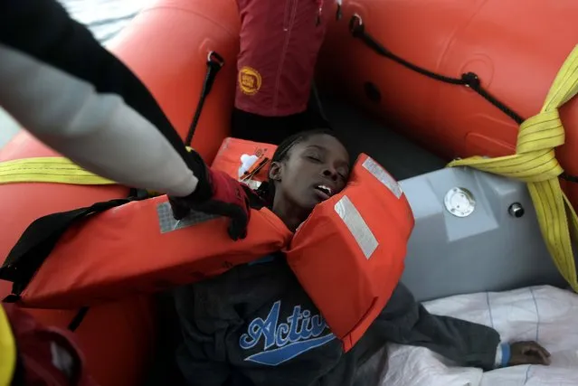 A woman has fainted after being rescued by members of Proactiva Open Arms NGO in the Mediterranean Sea, some 12 nautical miles north of Libya, on October 4, 2016. (Photo by Aris Messinis/AFP Photo)