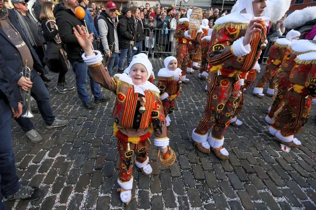 A child wearing a “Gilles” costume throws an orange, during the Binche carnival, a UNESCO World Heritage event, in Binche, Belgium on February 21, 2023. (Photo by Yves Herman/Reuters)