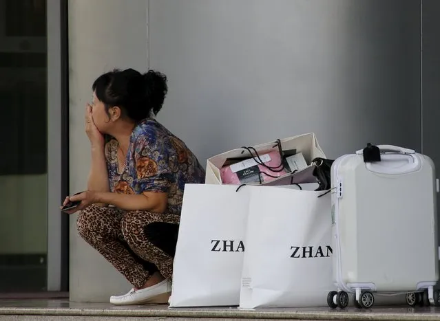 A woman sits next to her shopping bags nearby a shopping mall in Beijing, China, September 23, 2015. (Photo by Kim Kyung-Hoon/Reuters)