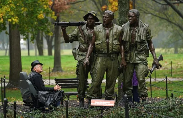 Doc Spresser, of Frankford, Delaware, who served in Vietnam from 1969 to 1970, looks up at “The Three Soldiers” statue while visiting the Vietnam Veterans Memorial on Veterans Day in Washington, November 11, 2020. (Photo by Kevin Lamarque/Reuters)