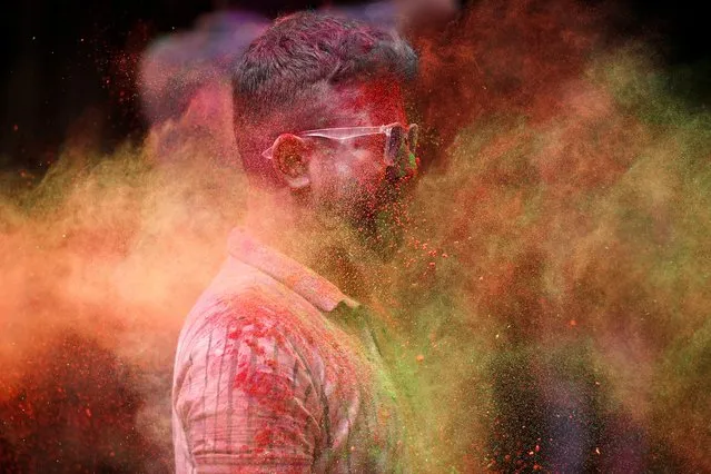 A man looks on as coloured powder is thrown at his face during Holi celebrations in Mumbai, India on March 7, 2023. (Photo by Francis Mascarenhas/Reuters)