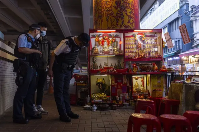 Police officers and a plainclothes police officer inspect a “villain hitting” booth during a routine patrol under the Canal Road Flyover in Hong Kong, on Sunday, March 5, 2023. (Photo by Louise Delmotte/AP Photo)