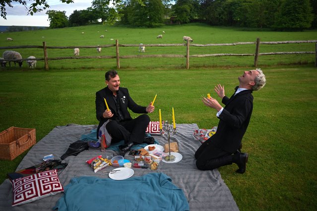 Opera fans attempt to light candles as they enjoy a picnic, during a 90-minute interval for Bizet's “Carmen” on the opening night of the Glyndebourne Opera Festival, in Glynde, Britain, on May 16, 2024. (Photo by Dylan Martinez/Reuters)