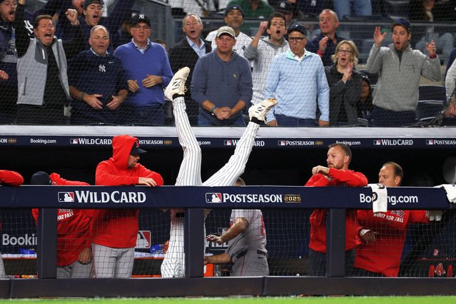 New York Yankees third baseman Ryan McMahon (19) falls into the Boston Red Sox dugout after making a catch of a popup in the eighth inning during game three of the Wildcard round for the 2025 MLB playoffs at Yankee Stadium in Bronx, New York on October 2, 2025. (Photo by Vincent Carchietta/Reuters)