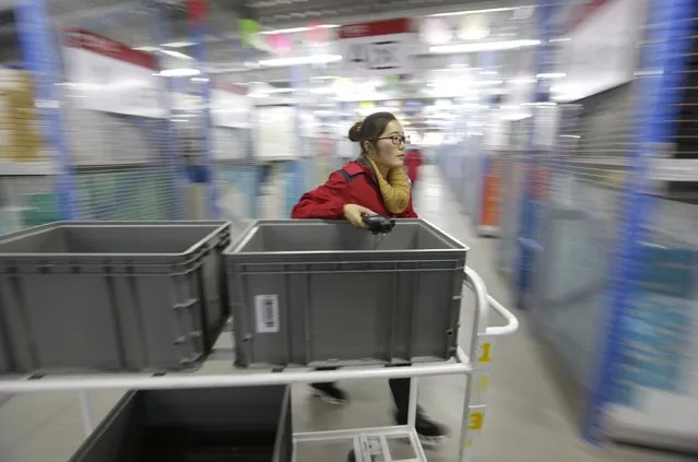 An employee works at a JD.com logistic centre in Langfang, Hebei province, November 10, 2015. On China's giant Singles Day internet shopping festival, the country's delivery firms are stretched so thin that they are looking for tie-ups, listings and new investors to husband their resources. (Photo by Jason Lee/Reuters)