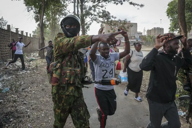Civilians returning from work are directed to a holding area to be checked by police before being allowed to continue to their homes, during protests in the Mathare slum of Nairobi, Kenya Monday, March 20, 2023. (Photo by Brian Inganga/AP Photo)