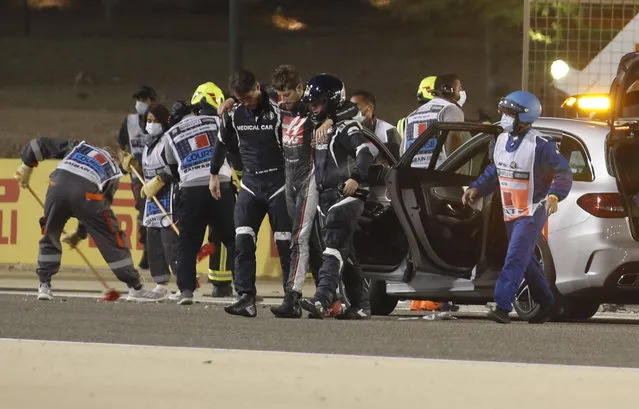 Haas driver Romain Grosjean of France is helped by medical staff after he crashed his car during the Formula One race in Bahrain International Circuit in Sakhir, Bahrain, Sunday, November 29, 2020. (Photo by Hamad Mohammed, Pool via AP Photo)